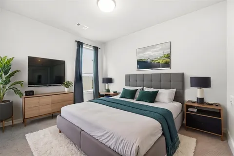 a bedroom with a large bed and a flat screen tv