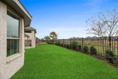 a view of a house with a yard and a large tree