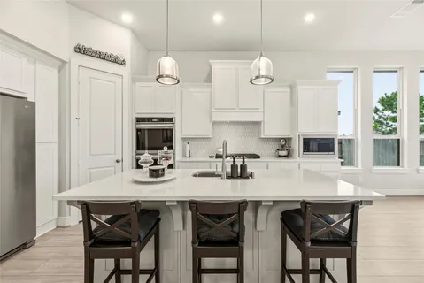 a kitchen with granite countertop a table chairs stove and cabinets
