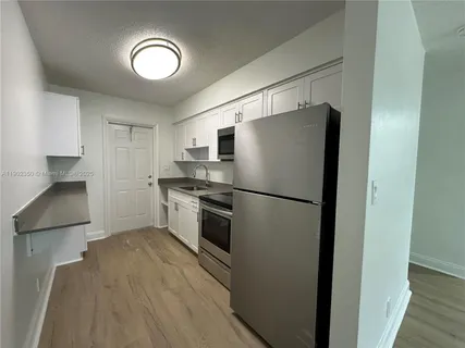 a kitchen with stainless steel appliances a refrigerator and a stove top oven