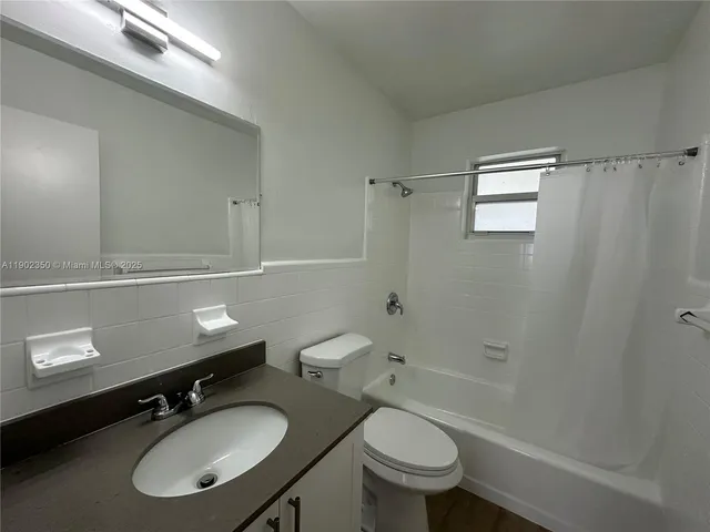 a bathroom with a sink toilet a mirror and shower