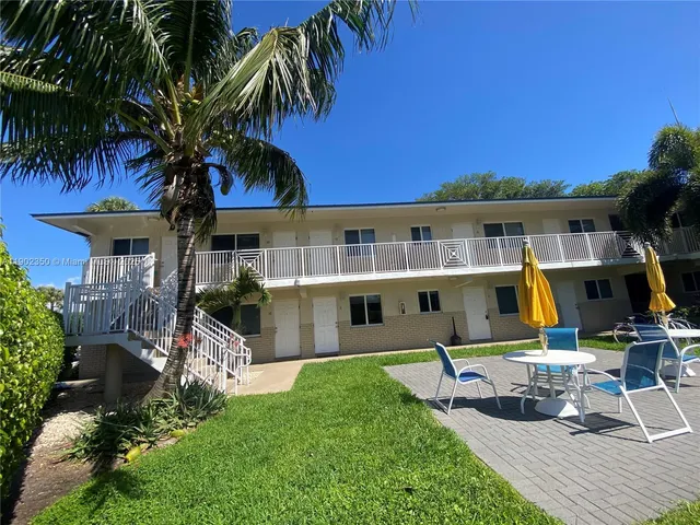 a view of backyard with swimming pool and seating space