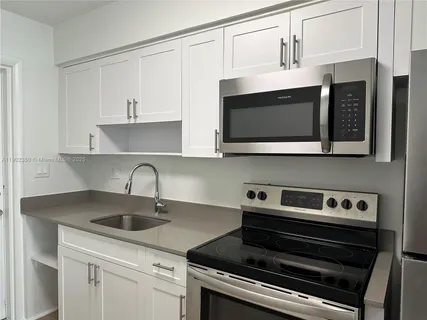 a kitchen with stainless steel appliances a sink a stove and cabinets