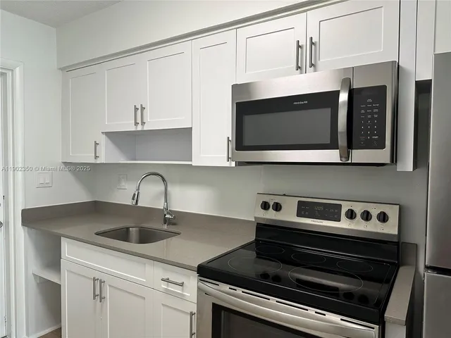 a kitchen with stainless steel appliances a sink a stove and cabinets