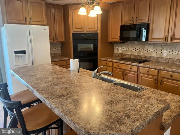a kitchen with kitchen island a counter top space cabinets and stainless steel appliances