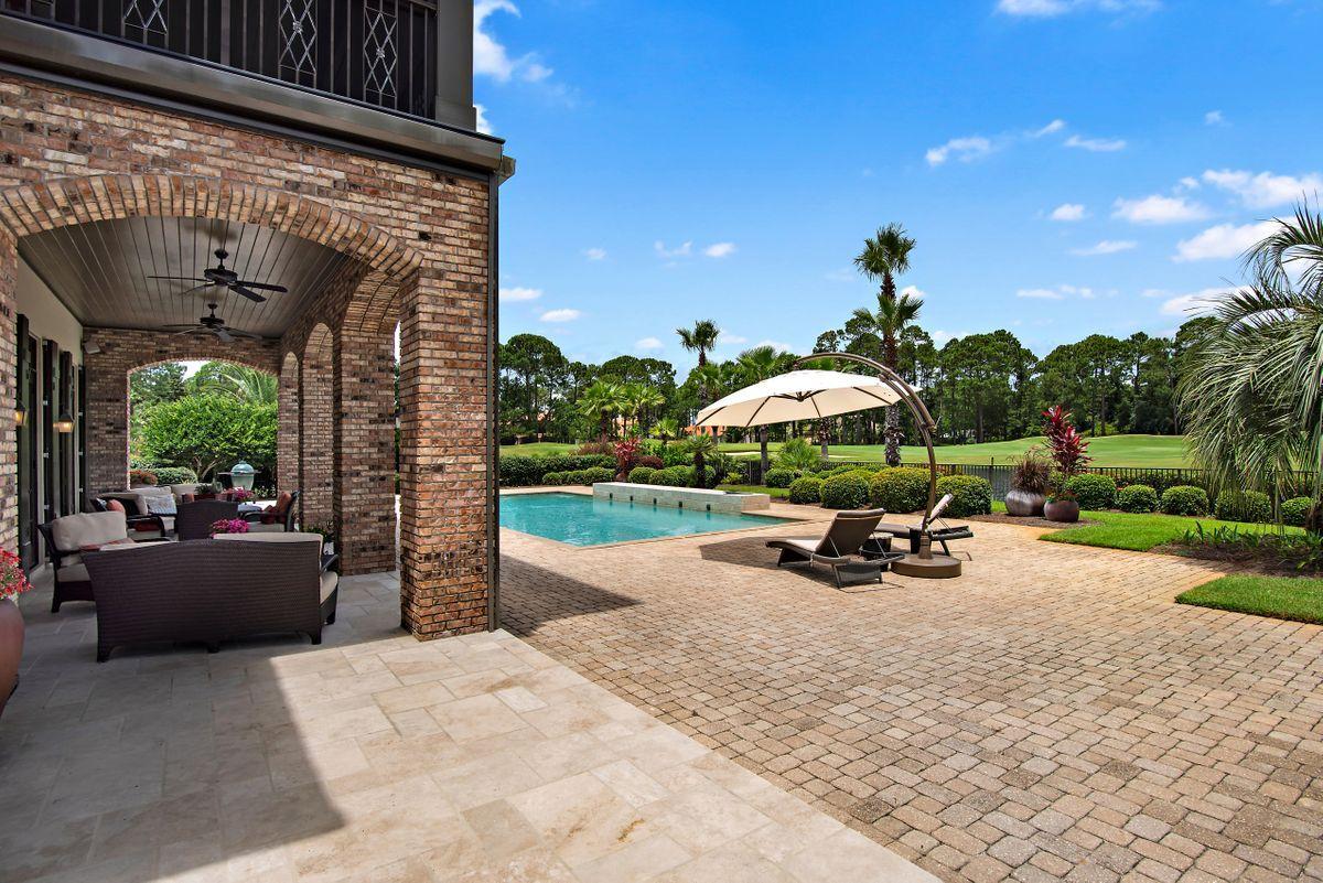 2955 Pine Valley Road Miramar Beach, FL 32550 - Photo 5 of 33 a view of a patio with a table and chairs under an umbrella with a fire pit and a garden