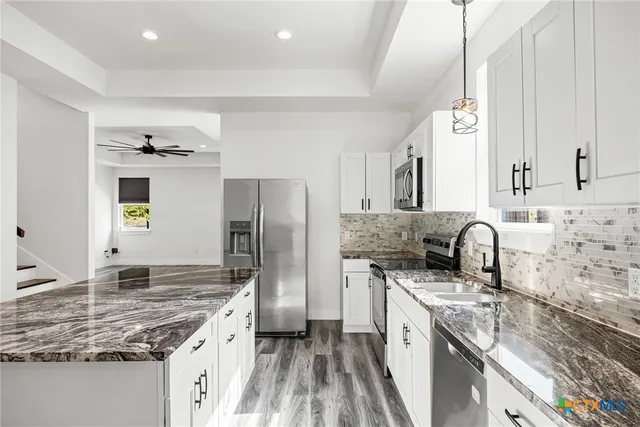 a kitchen with stainless steel appliances granite countertop a sink stove and refrigerator