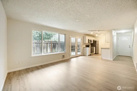 an empty room with wooden floor and a fireplace