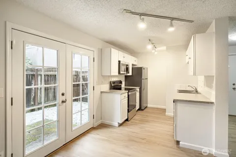 a kitchen with white cabinets and appliances