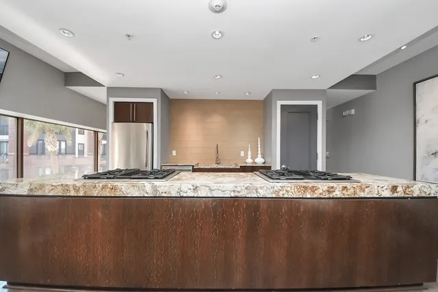 a large kitchen with stainless steel appliances kitchen island granite countertop a large counter top and a stove