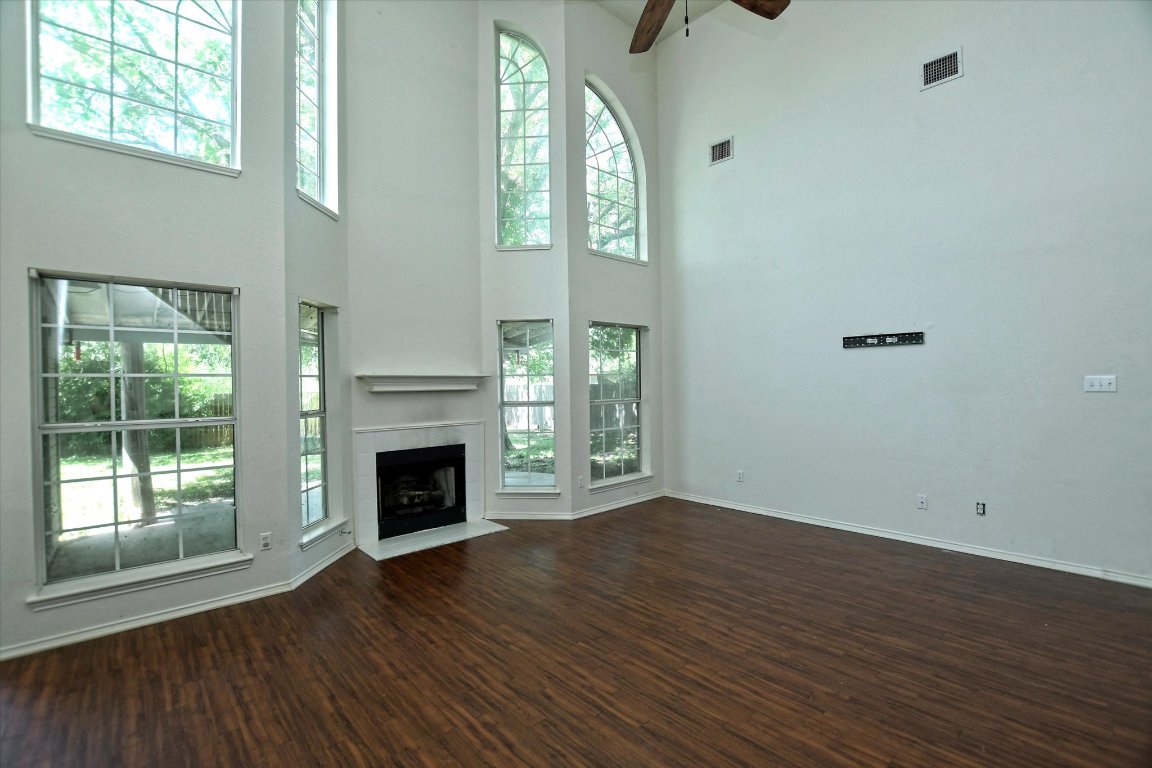 301 Gulfstream Drive Georgetown, TX 78626 - Photo 11 of 35 an empty room with wooden floor fireplace and windows