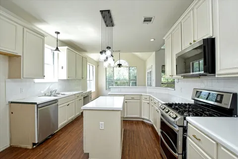 a kitchen with a sink stove top oven and cabinets