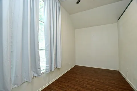 a view of a room with wooden floor and bench