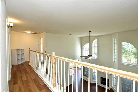 a view of a hallway with wooden floor and windows