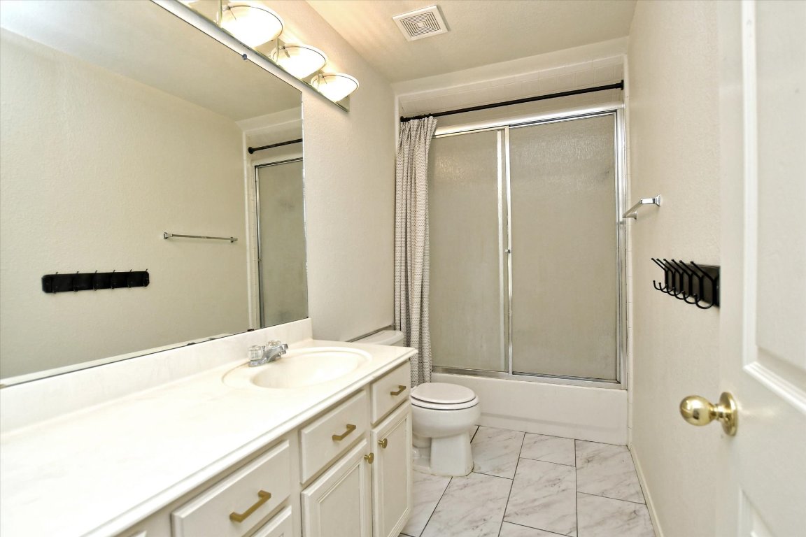 301 Gulfstream Drive Georgetown, TX 78626 - Photo 27 of 35 a bathroom with a granite countertop sink a toilet and shower