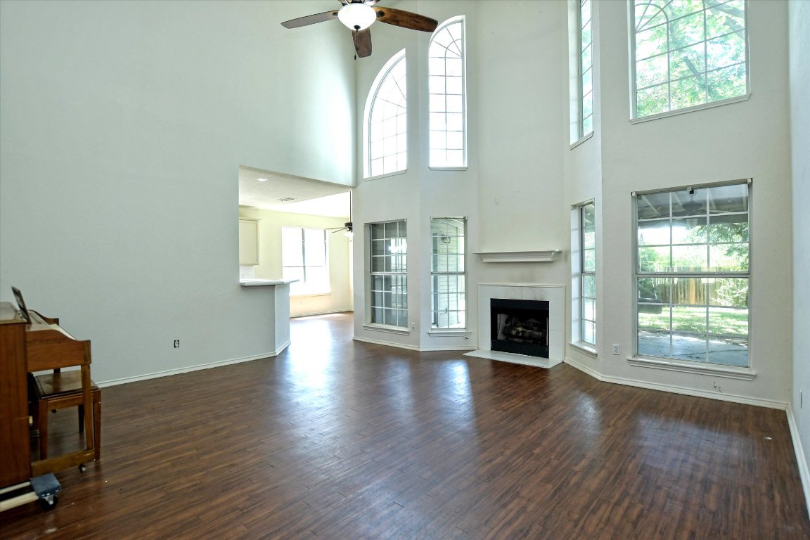 301 Gulfstream Drive Georgetown, TX 78626 - Photo 10 of 35 an empty room with wooden floor fireplace and windows