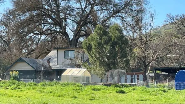 a backyard of a house with plants and outdoor seating