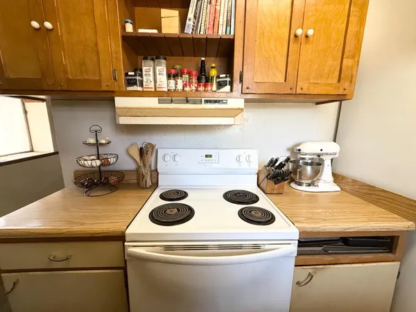 a kitchen with a stove and a white cabinets