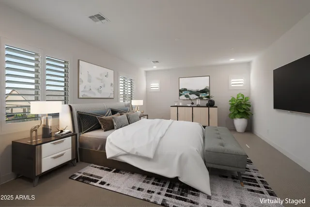 a bedroom with a bed a couch and a flat screen tv