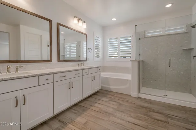 a bathroom with a granite countertop sink mirror and a bathtub