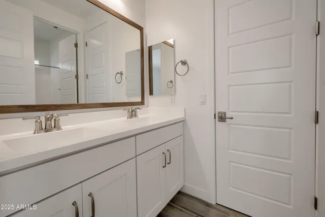 a bathroom with a double vanity sink and a mirror