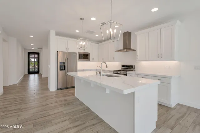 a large kitchen with stainless steel appliances kitchen island a large counter top and stove top oven