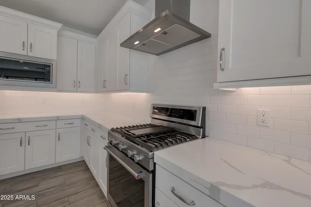 a kitchen with cabinets and steel appliances