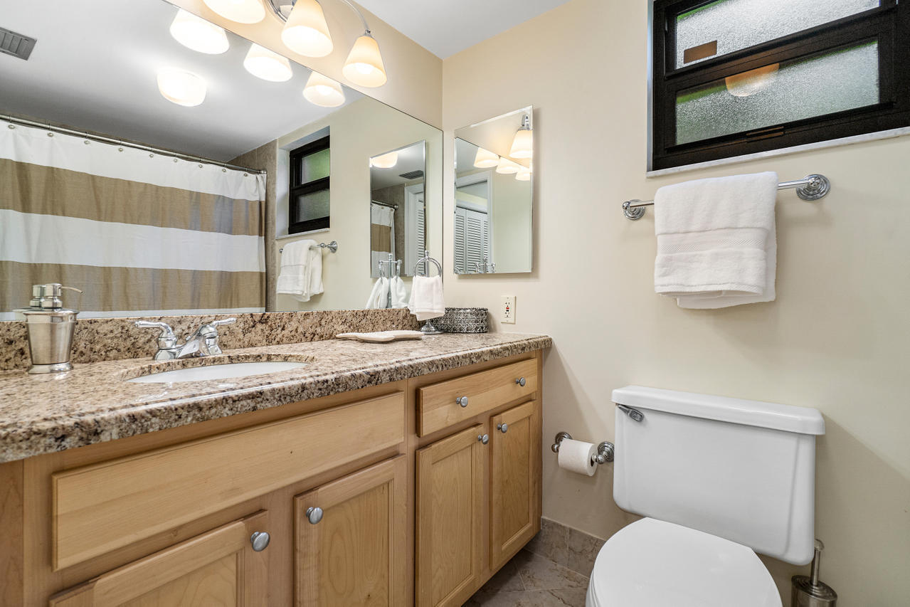 13334 Polo Club Road, Unit 238 Wellington, FL 33414 - Photo 12 of 13 a bathroom with a granite countertop toilet sink and mirror