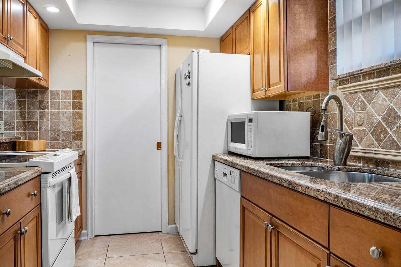 13334 Polo Club Road, Unit 238 Wellington, FL 33414 - Photo 4 of 13 a kitchen with stainless steel appliances granite countertop a refrigerator and a stove