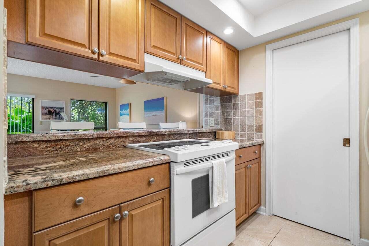 13334 Polo Club Road, Unit 238 Wellington, FL 33414 - Photo 5 of 13 a kitchen with granite countertop cabinets stainless steel appliances and a counter space
