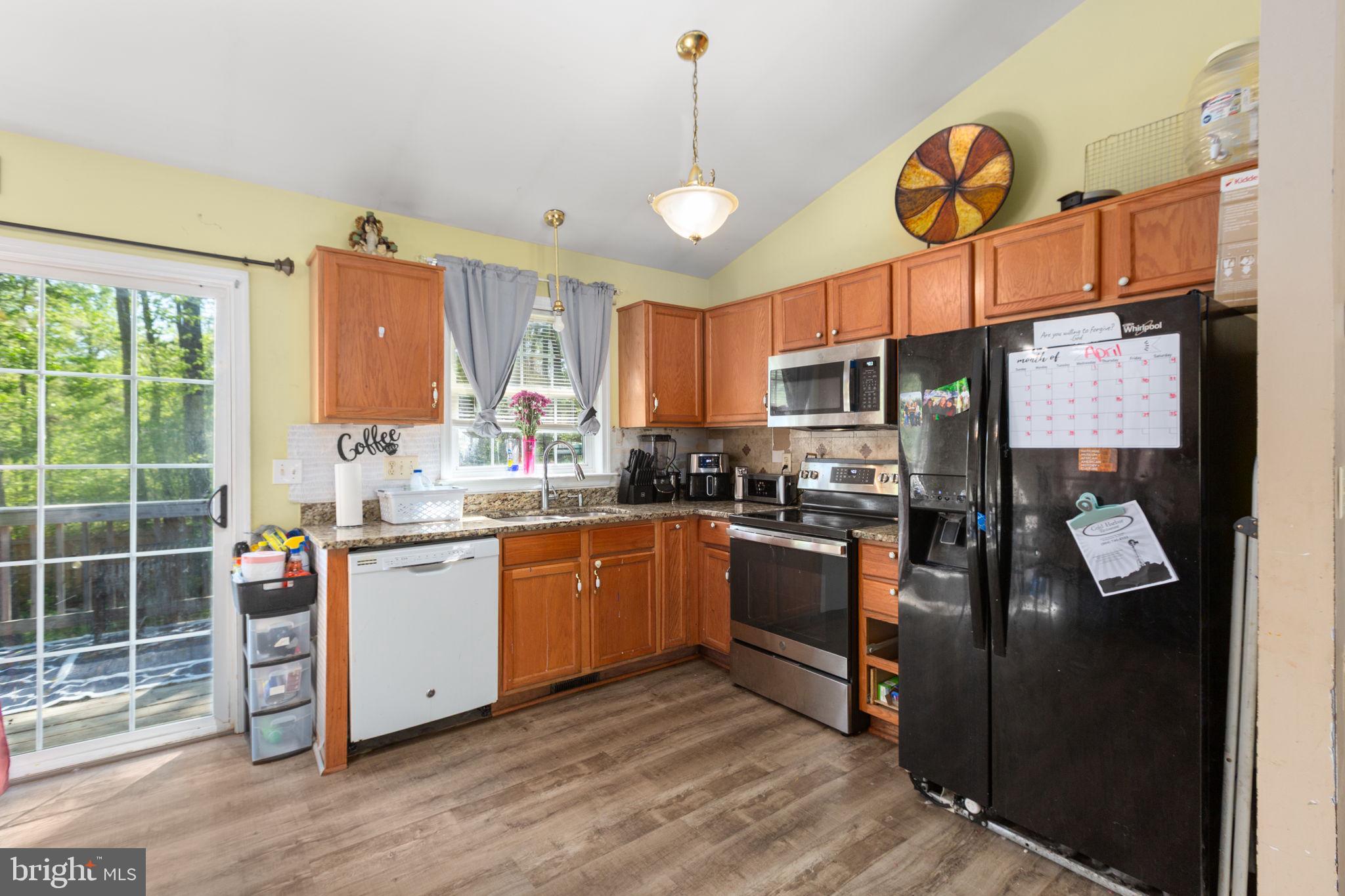 877 Campers Lane Ruther Glen, VA 22546 - Photo 5 of 13 a kitchen with stainless steel appliances granite countertop a stove refrigerator and cabinets