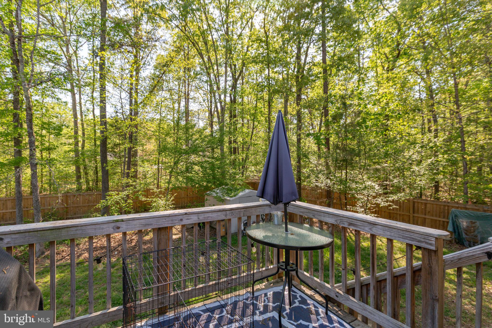 877 Campers Lane Ruther Glen, VA 22546 - Photo 9 of 13 a view of a balcony with chairs and wooden fence