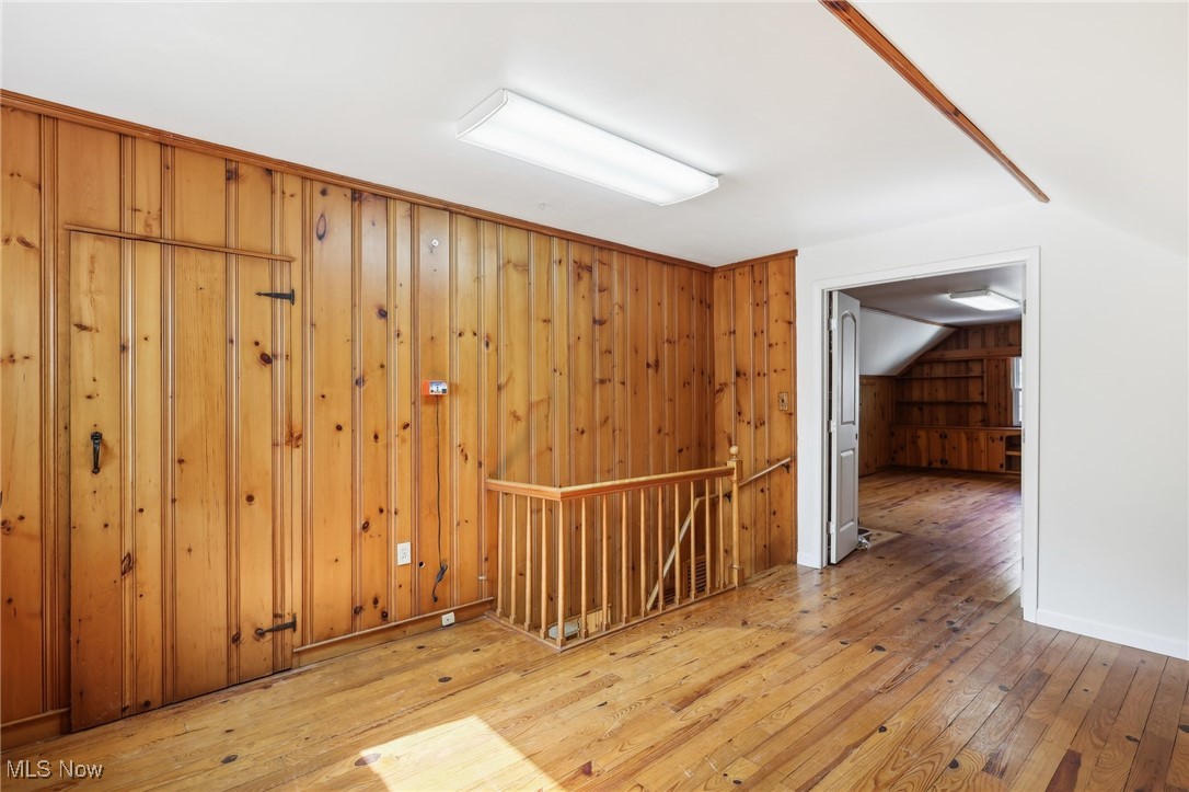 1042 Renfield Road Cleveland Heights, OH 44121 - Photo 26 of 49 Unfurnished room with light wood-type flooring, lofted ceiling, and wooden walls