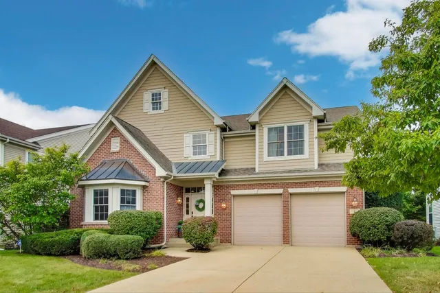 a front view of a house with a yard and trees