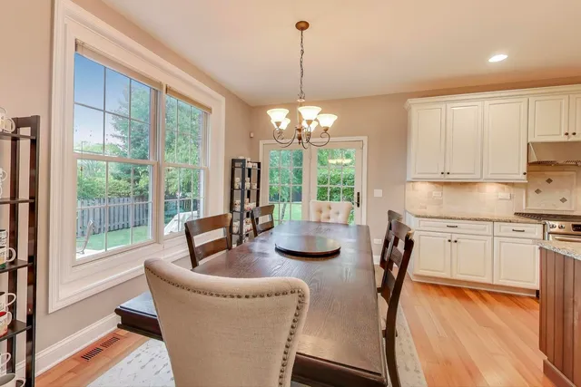 a dining room with furniture a chandelier and wooden floor