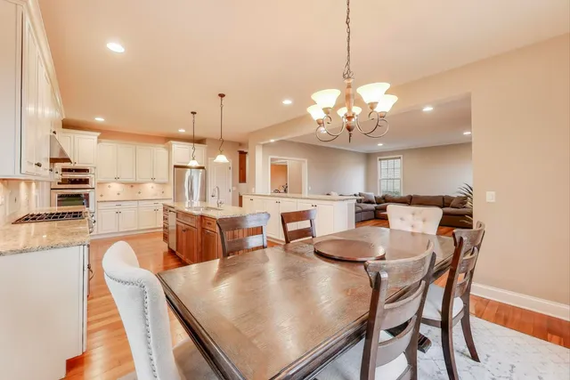 a dining room filled chandelier and kitchen view
