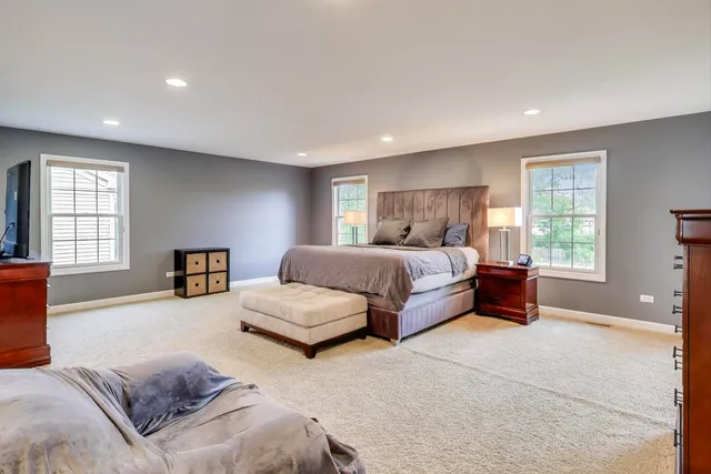 a spacious bedroom with a bed and glass window