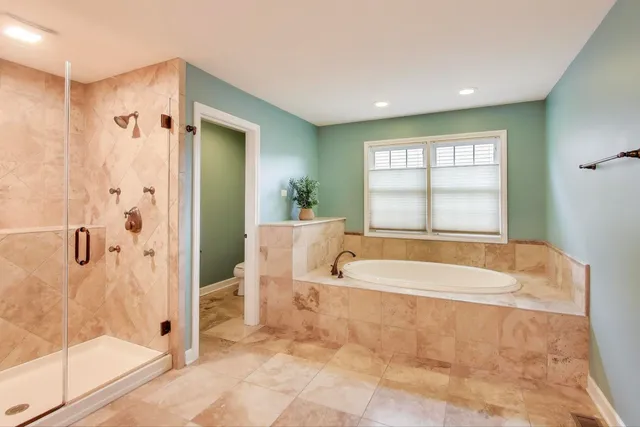 a spacious bathroom with a bathtub and shower