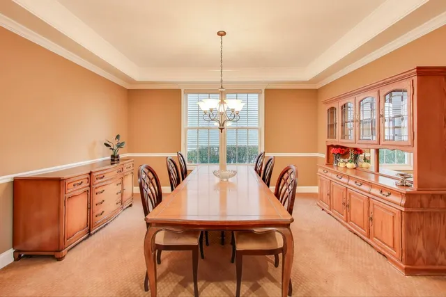a dining room with furniture a chandelier and window