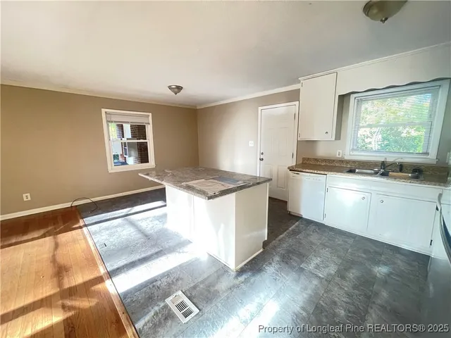 a large white kitchen with a sink and cabinets