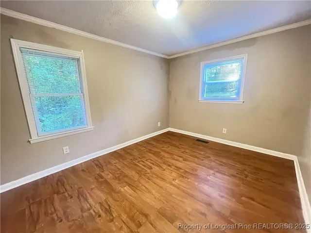 a view of empty room with wooden floor
