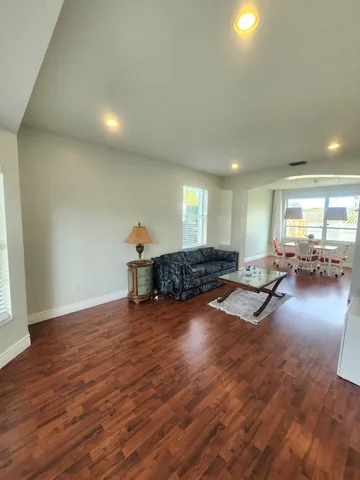 a living room with furniture and a wooden floor