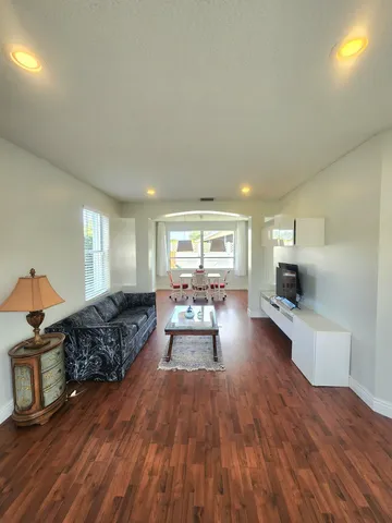 a living room with furniture and a wooden floor