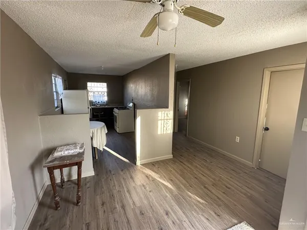 a kitchen with a refrigerator and wooden floor