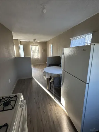 a kitchen with a refrigerator and wooden floor
