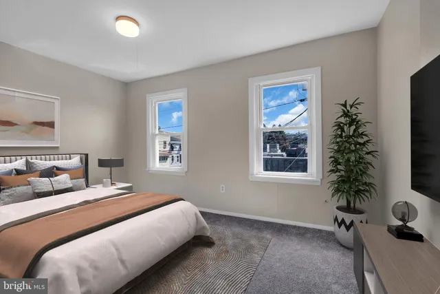 a bedroom with a large bed and a potted plant