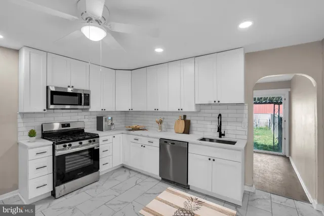 a kitchen with white cabinets stainless steel appliances and sink