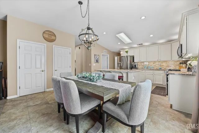 a spacious bedroom with a bed a couch and a chandelier