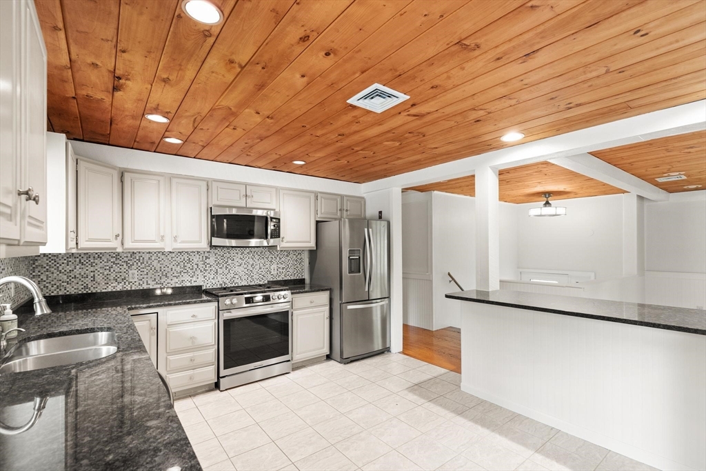 901 Haverhill Street Rowley, MA 01969 - Photo 6 of 42 a kitchen with stainless steel appliances granite countertop a stove a refrigerator and a microwave