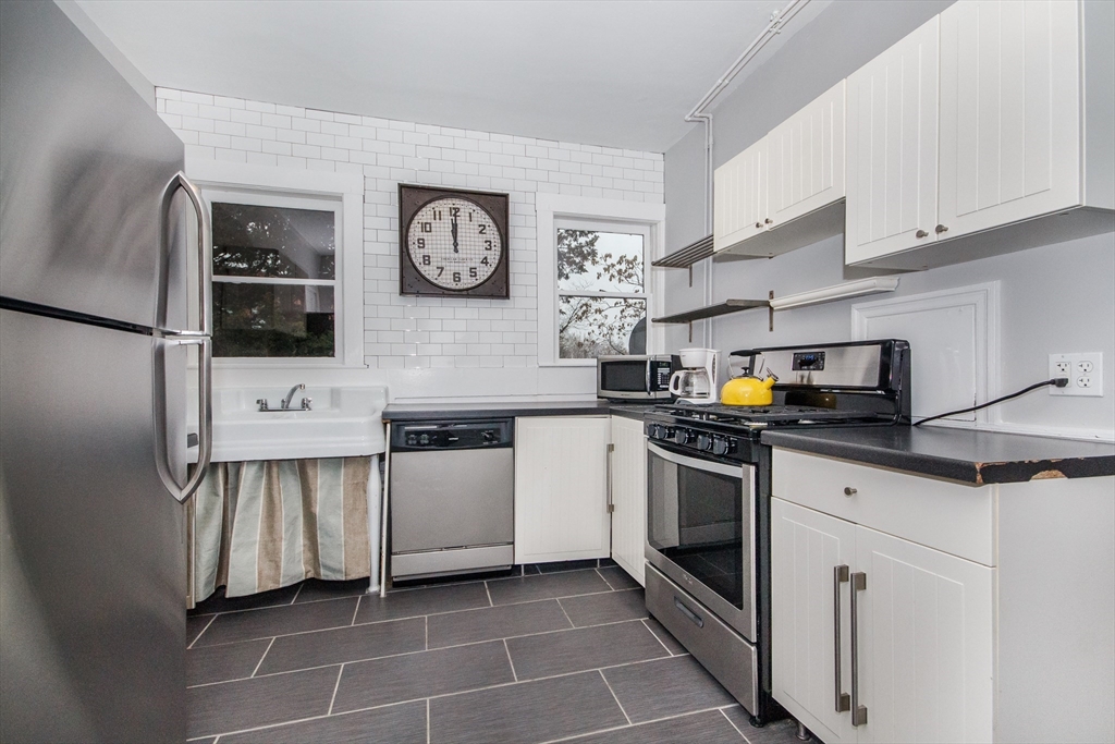 584 Centre Street Boston, MA 02130 - Photo 18 of 29 a kitchen with stainless steel appliances a stove a refrigerator and a white cabinets